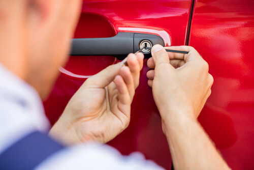 car locksmith unlocking a red car